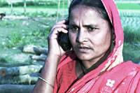 Fattig kvinde taler i en mobiltelefon, som hun har lnt penge til gennem mikrokreditorganisationen Grameen Bank (foto: Michael Lund)